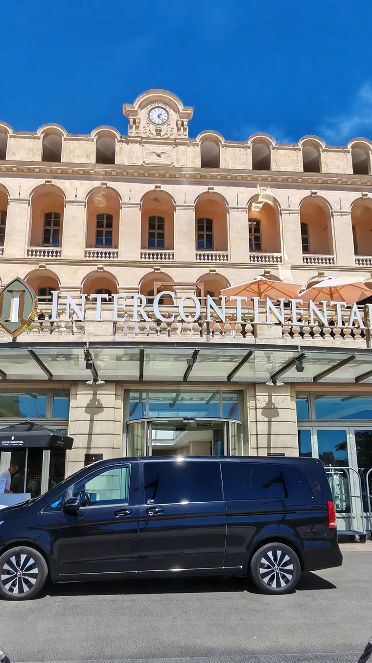 Van Mercedes Classe V noir d'Urban Prestige devant la façade d'un hôtel InterContinental 5 étoiles